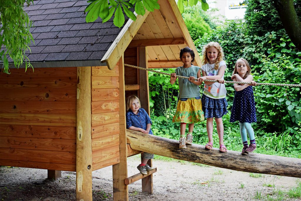 Holzhütte auf Stelzen an der 4 Mädchen entlang balancieren - FREIO Naturspielräume